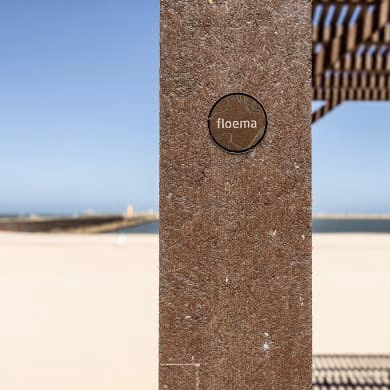 Detalhe de poste de pérgula de praia em plástico reciclado castanho com medalha da Floema.