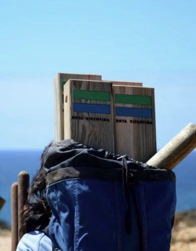 Pessoa a transportar balizas para percursos pedestres em madeira da Rota Vicentina.