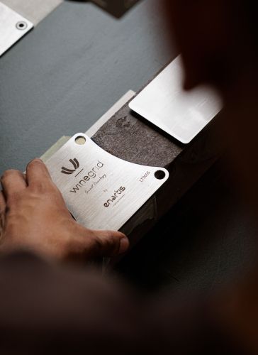 Detalhe de instalação de medalha em aço inoxidável para enoturismo, com estrutura em plástico reciclado.