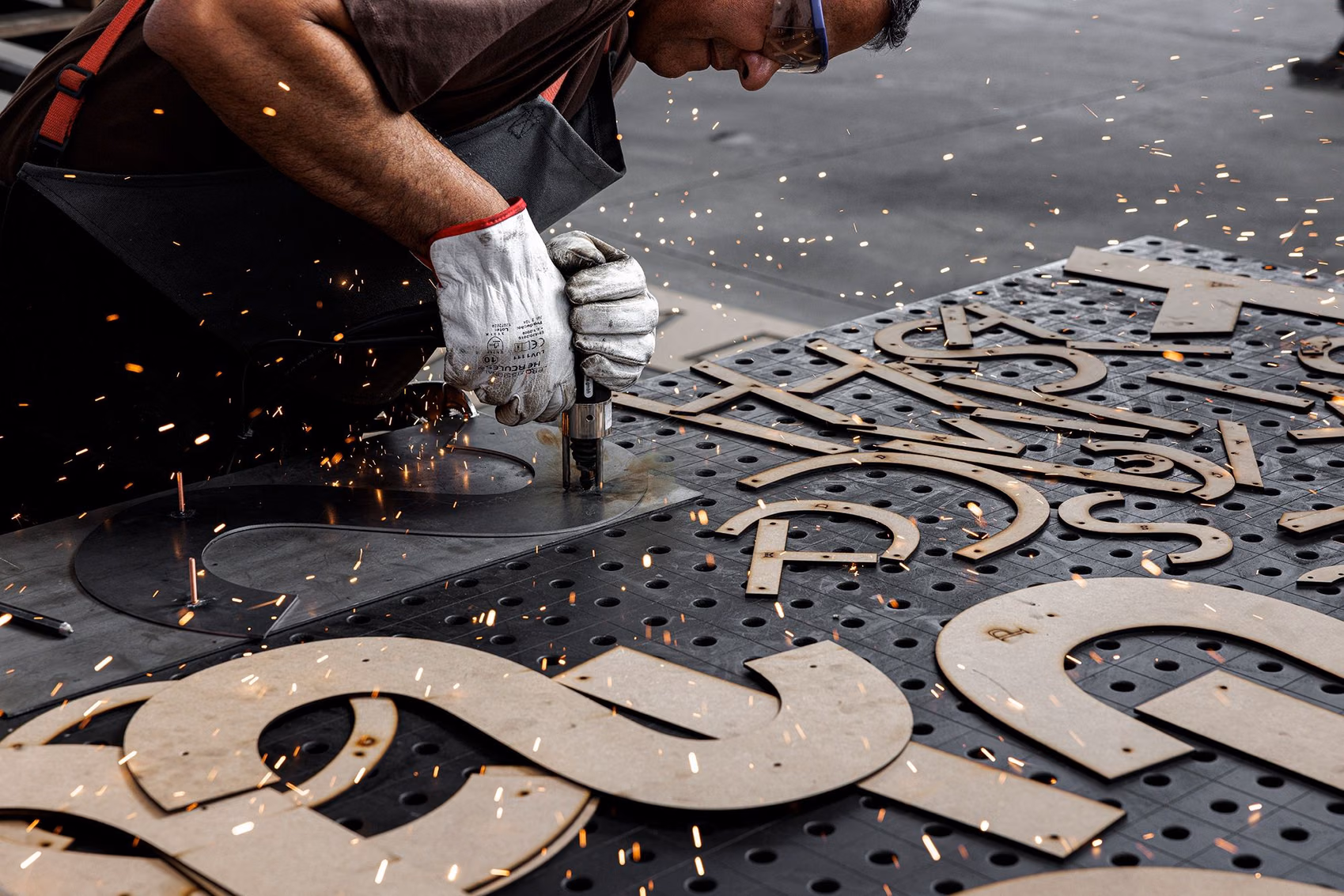 Serralheiro a trabalhar lettering de fachada metálico para a Floema Details.